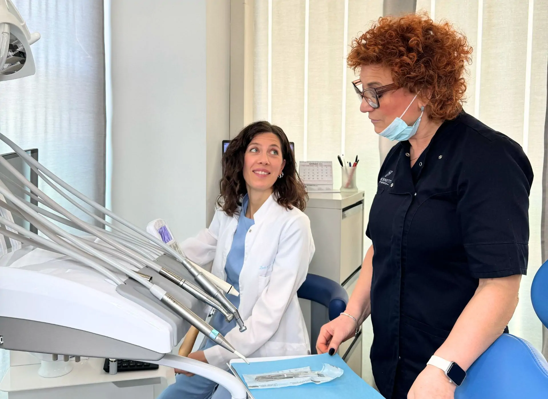 Odontoiatra e assistente di Facchinetti Dental a colloquio in una sala di cura del centro di Manerbio