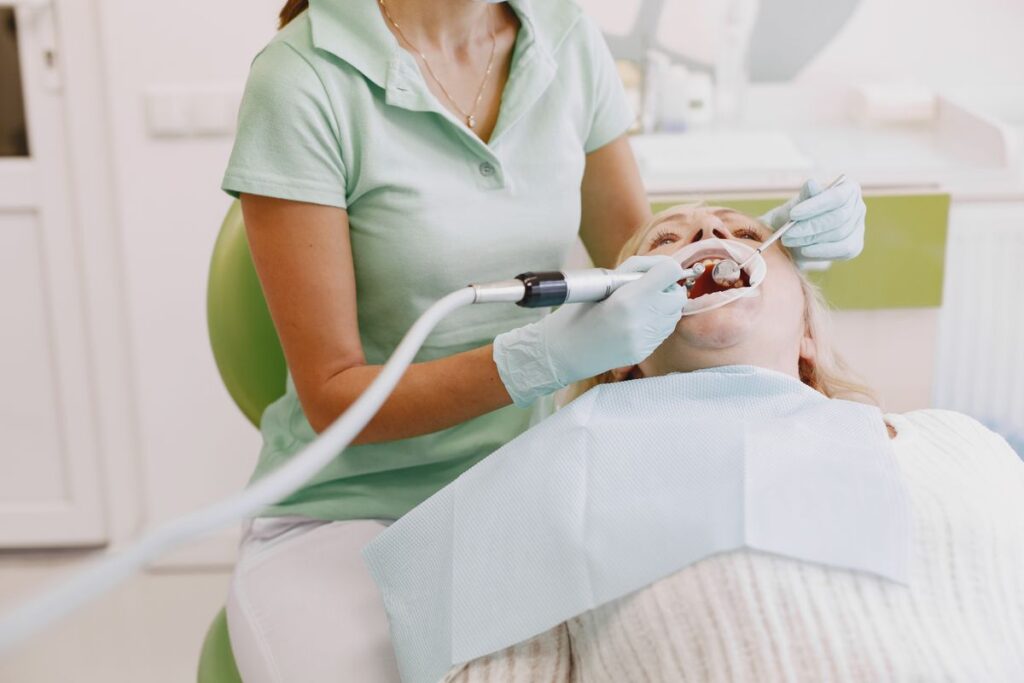 Dentista al lavoro su un paziente durante una seduta di implantologia