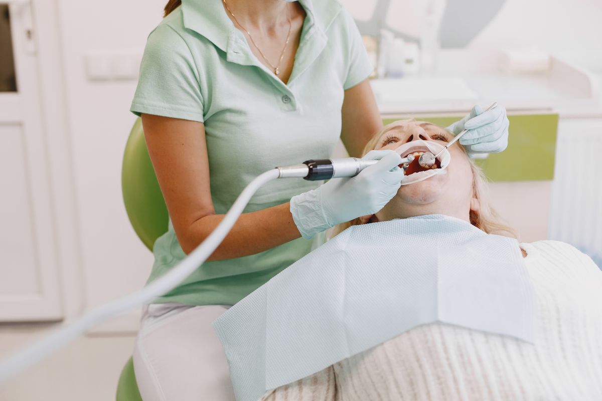 Dentista al lavoro su un paziente durante una seduta di implantologia