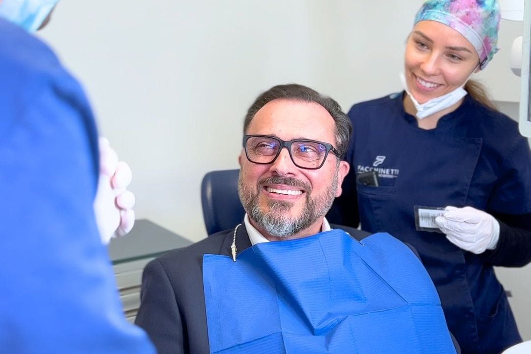 Prima visita nel centro Facchinetti Dental: paziente sorridente sulla poltrona con il team